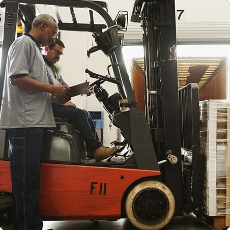 Forklift dan tim memeriksa barang di gudang untuk rantai pasok